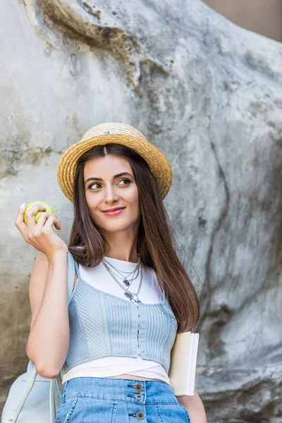 通りに新鮮なリンゴと帽子でスタイリッシュな女性の肖像画  — 無料ストックフォト