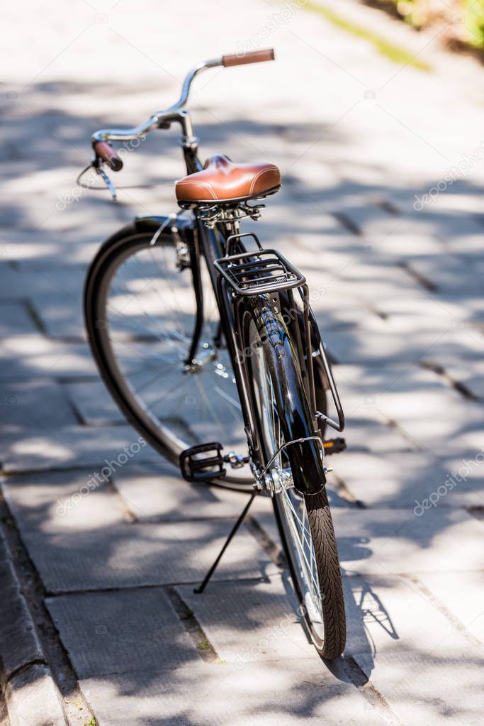 close up view of black retro bicycle parked on street