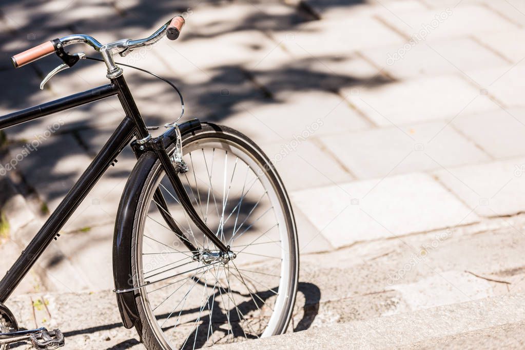 close up view of black retro bicycle parked on street