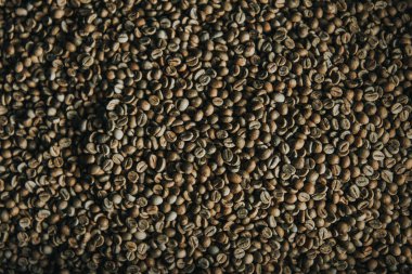 Raw coffee beans in process of roasting texture clipart