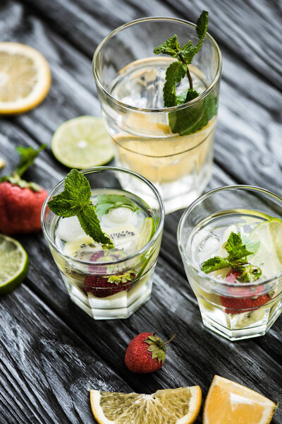 fresh cold summer cocktails in glasses and ingredients on wooden table 
