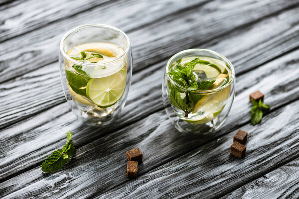 high angle view of glasses with cold fresh mojito on wooden table
