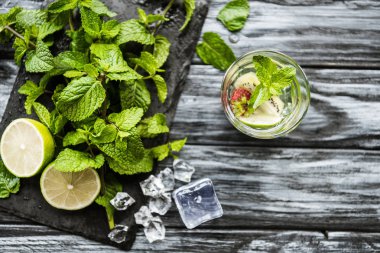 top view of glass with fresh cold strawberry and kiwi mojito on wooden table  clipart