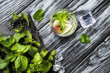 ahşap masa üzerinde taze çilek ve kivi Mojito cam üstten görünüm