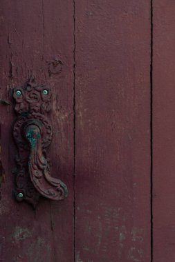 close-up view of vintage decorative door handle on old wooden door clipart