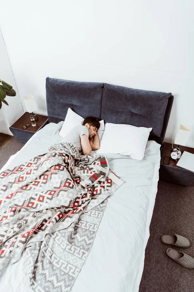 自宅のベッドで寝ている若い男のハイアングル  — 無料ストックフォト