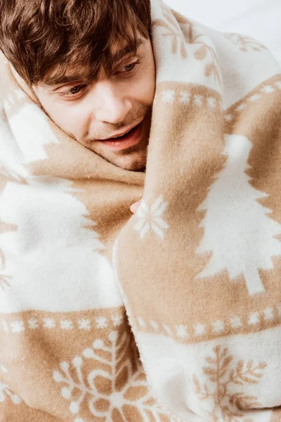 自宅のベッドの上に座って毛布に包まれた幸せな男の肖像  — 無料ストックフォト
