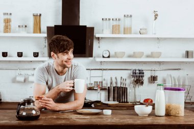 tost ve kahve makinesini evde mutfak masasında içme kahve mutlu genç adam