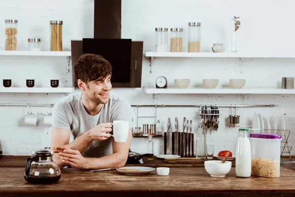Glücklicher Junger Mann Trinkt Kaffee Tisch Mit Toasts Und Kaffeekanne — Stockfoto