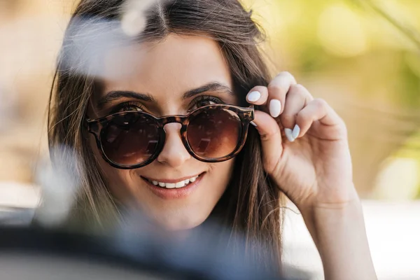Portrait of of beautiful young woman in sunglasses on street — Stock Photo