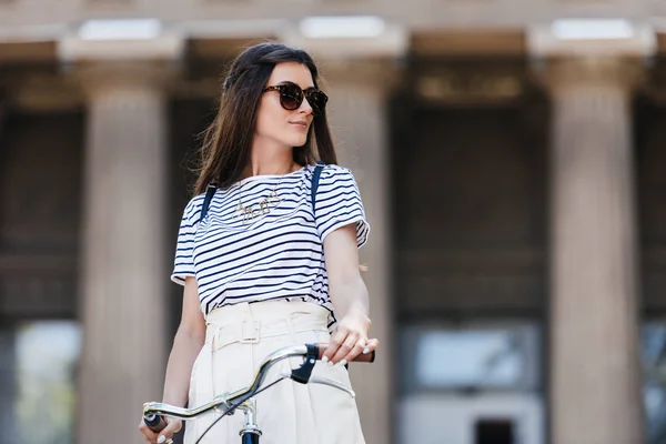 Portrait of stylish young woman in sunglasses with retro bicycle on street — Stock Photo