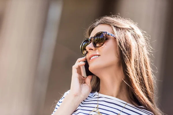 Porträt einer jungen hübschen Frau mit Sonnenbrille im Smartphone-Gespräch — Stockfoto