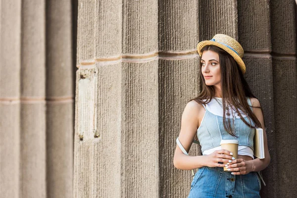 Портрет молодой задумчивой женщины с книгой и кофе на улице — стоковое фото