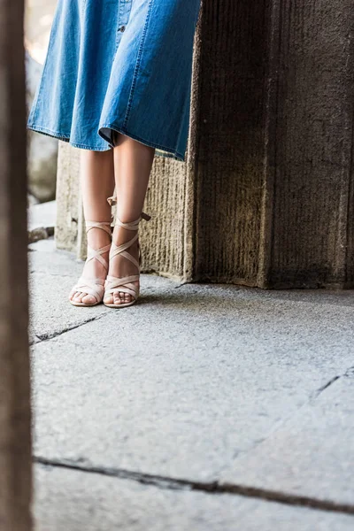 Cropped shot of woman in denim skirt and stylish shoes on street — Stock Photo