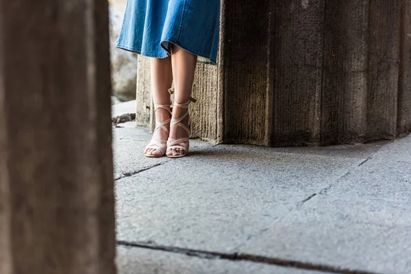 Cropped shot of woman in denim skirt and shoes standing on street — Stock Photo