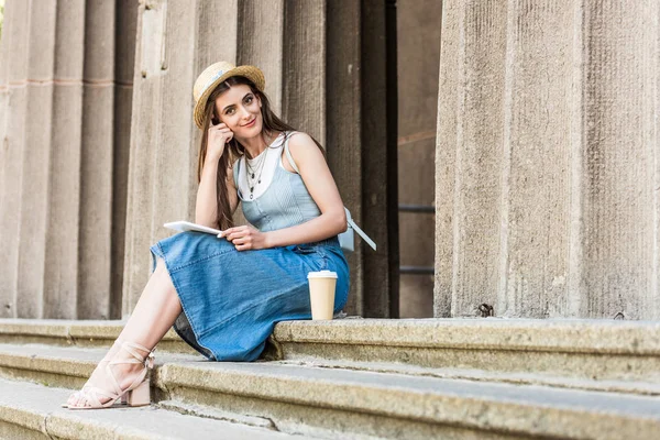 Giovane donna sorridente con tablet e caffè per sedersi sui gradini — Foto stock