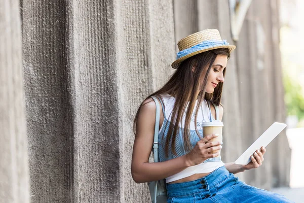 Portrait de jeune femme avec café pour aller à l'aide tablette sur la rue — Photo de stock