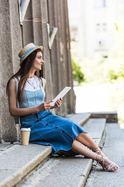 Молода усміхнена жінка з планшетом і кавою, щоб піти відпочивати на сходинках на вулиці — Stock Photo