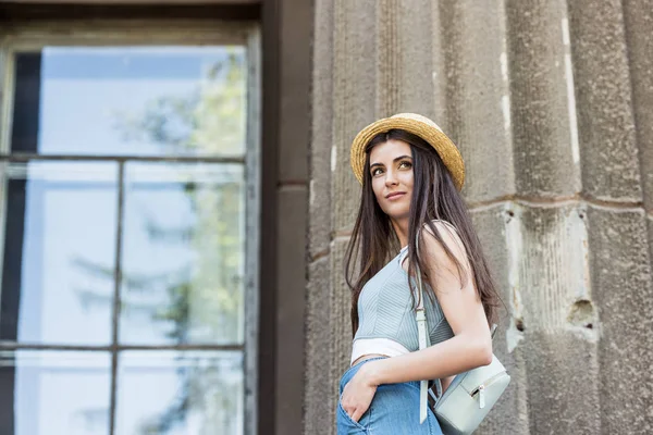 Seitenansicht einer jungen schönen Frau mit Strohhut auf der Straße — Stockfoto