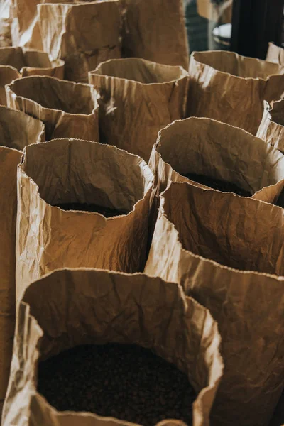 Sacs en papier artisanal avec grains de café fraîchement torréfiés — Photo de stock