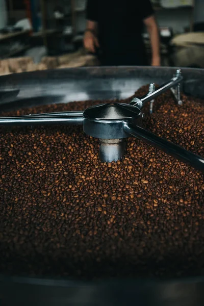 Vista ravvicinata dei chicchi di caffè tostati in macchina professionale — Foto stock