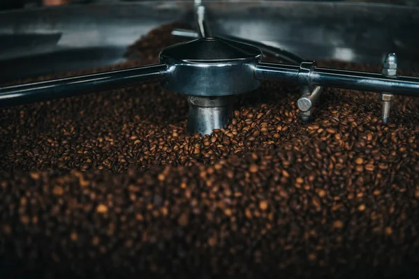 Les grains de café aromatiques étant torréfiés dans la machine professionnelle — Photo de stock