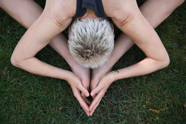 Top view of woman practicing yoga on grass in park — Stock Photo