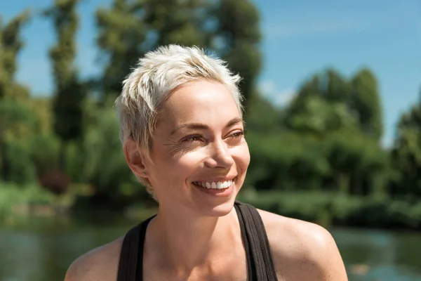 Portrait of beautiful smiling woman looking away in park — Stock Photo
