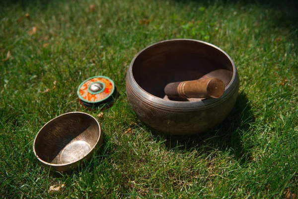 Tibetan singing bowls on green grass in park — Stock Photo