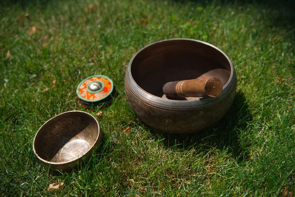 Tibetische Klangschalen auf grünem Gras im Park — Stockfoto