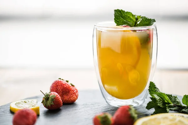 Vista de cerca de vidrio con cóctel de verano jugoso con menta y fresas - foto de stock