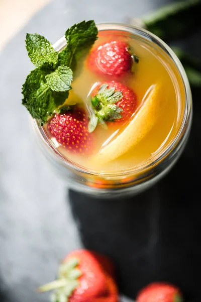 Vista superior de delicioso cóctel de verano jugoso con menta y fresas en vidrio - foto de stock