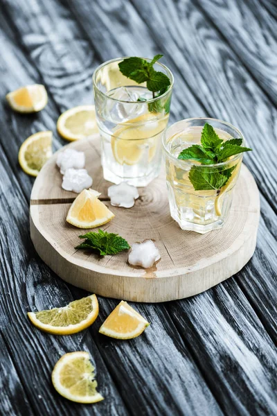 Cocktail de verão fresco frio com cubos de menta e gelo em copos na mesa de madeira — Fotografia de Stock