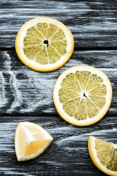 Вид сверху на ломтики свежего лимона на деревянном столе — стоковое фото