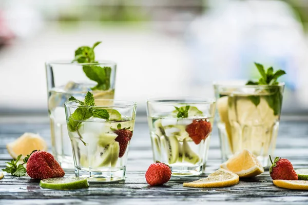 Vista close-up de óculos com bebidas frescas frias de verão em mesa de madeira — Fotografia de Stock