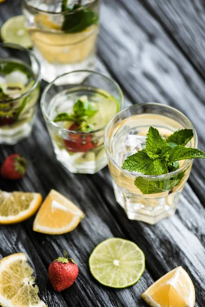 Vue rapprochée de cocktails d'été frais et froids dans des verres sur une table en bois — Photo de stock