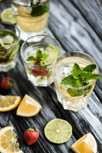 Nahaufnahme frischer kalter Sommercocktails in Gläsern auf Holztisch — Stockfoto