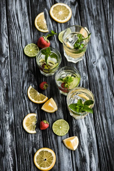 Top view of fresh cold summer cocktails in glasses on wooden table — Stock Photo