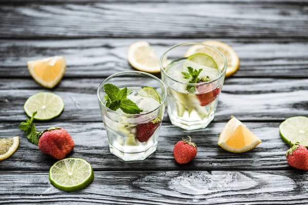 Vue grand angle de délicieux cocktail mojito fraise dans des verres sur une table en bois — Photo de stock