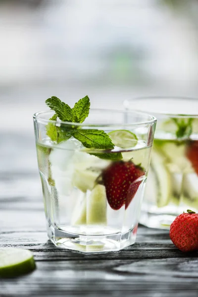 Delicious strawberry mojito cocktail in glasses on wooden table — Stock Photo