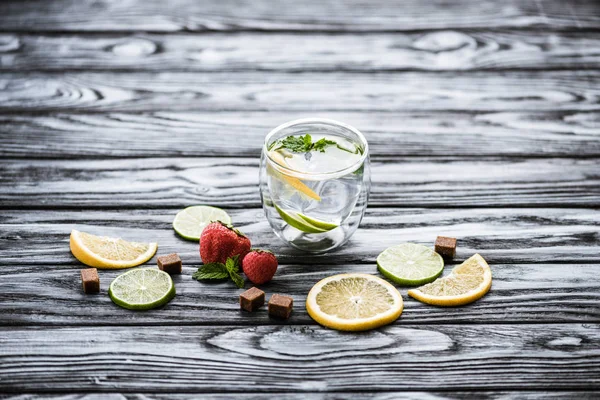 Fresh cold lemonade in glass and ripe ripe strawberries on wooden table — Stock Photo