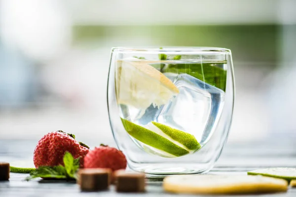 Vista close-up de limonada fria fresca em vidro e morangos maduros na mesa — Fotografia de Stock