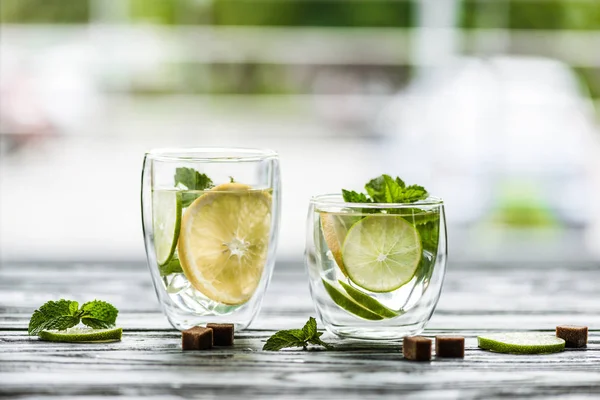 Close-up view of two glasses with fresh cold mojito on table — Stock Photo