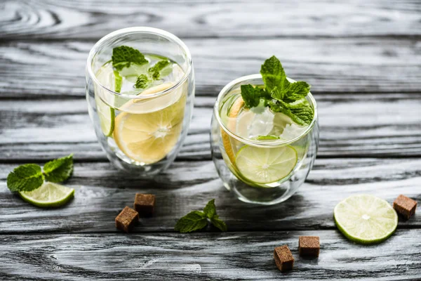 Vue rapprochée d'un cocktail de mojito froid frais dans des verres sur une table en bois — Photo de stock