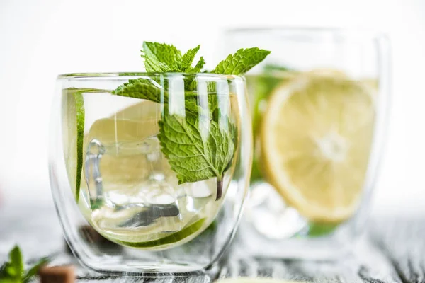 Selektiver Fokus von frischem, kaltem Mojito-Cocktail in Gläsern auf Holztisch — Stockfoto