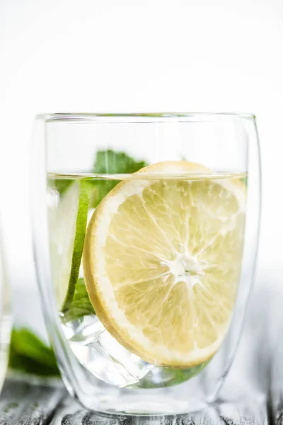 Vista de cerca del cóctel fresco de mojito frío en vaso sobre mesa de madera - foto de stock