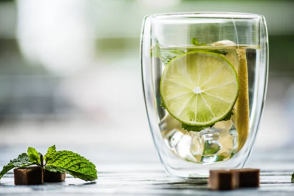 Vista de cerca del vaso de mojito fresco frío con lima, menta y azúcar - foto de stock