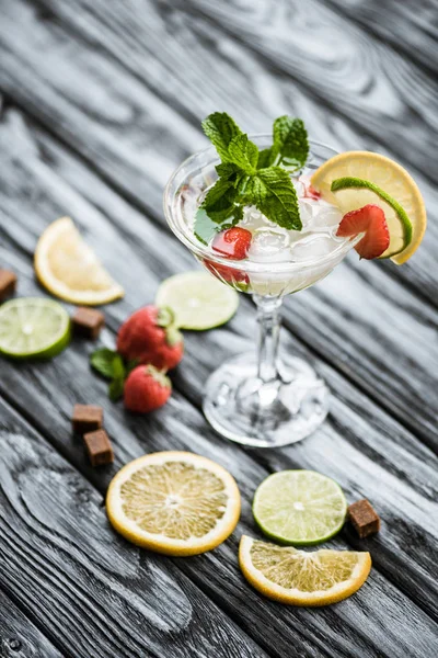 Close-up view of fresh summer cocktail with mint and fruits in glass on wooden table — Stock Photo