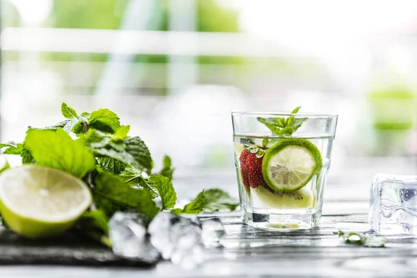 Close-up view of glass with fresh strawberry and kiwi mojito — Stock Photo