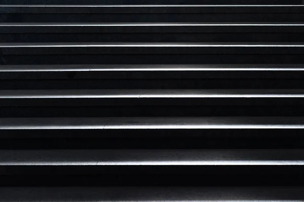 Shiny horizontal metal strips on black — Stock Photo